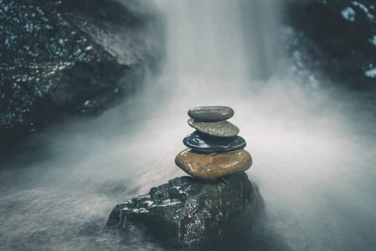 Stones in a waterfall, symbolizing using the window of tolerance for trauma recovery to balance the nervous system
