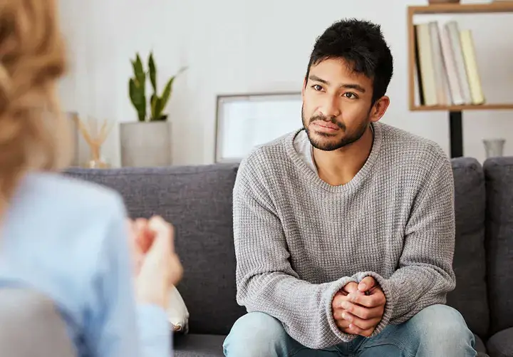 Man listening attentively during a trauma-informed counselling session for anxiety, reflecting openness to support and healing.