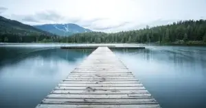 Peaceful lake with a wooden pier, symbolizing reflection, calm, and taking steps to stop stalking and protect oneself from abusive relationships.
