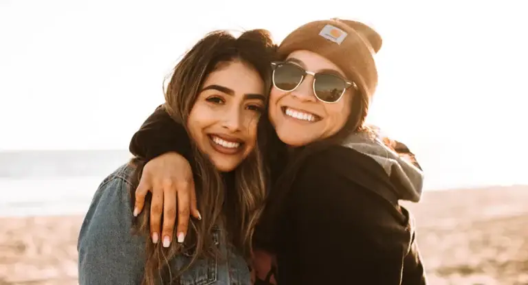 Two people hugging outdoors, smiling and enjoying a sense of freedom after receiving trauma-informed care.