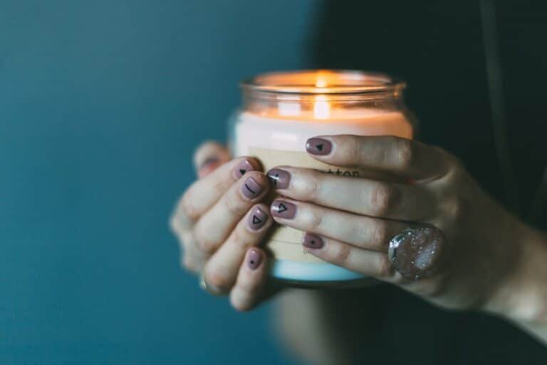 Hand holding a candle, representing what are best practices for trauma treatment and promoting healing and safety