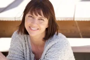 The image shows a happy woman after doing online trauma counselling.