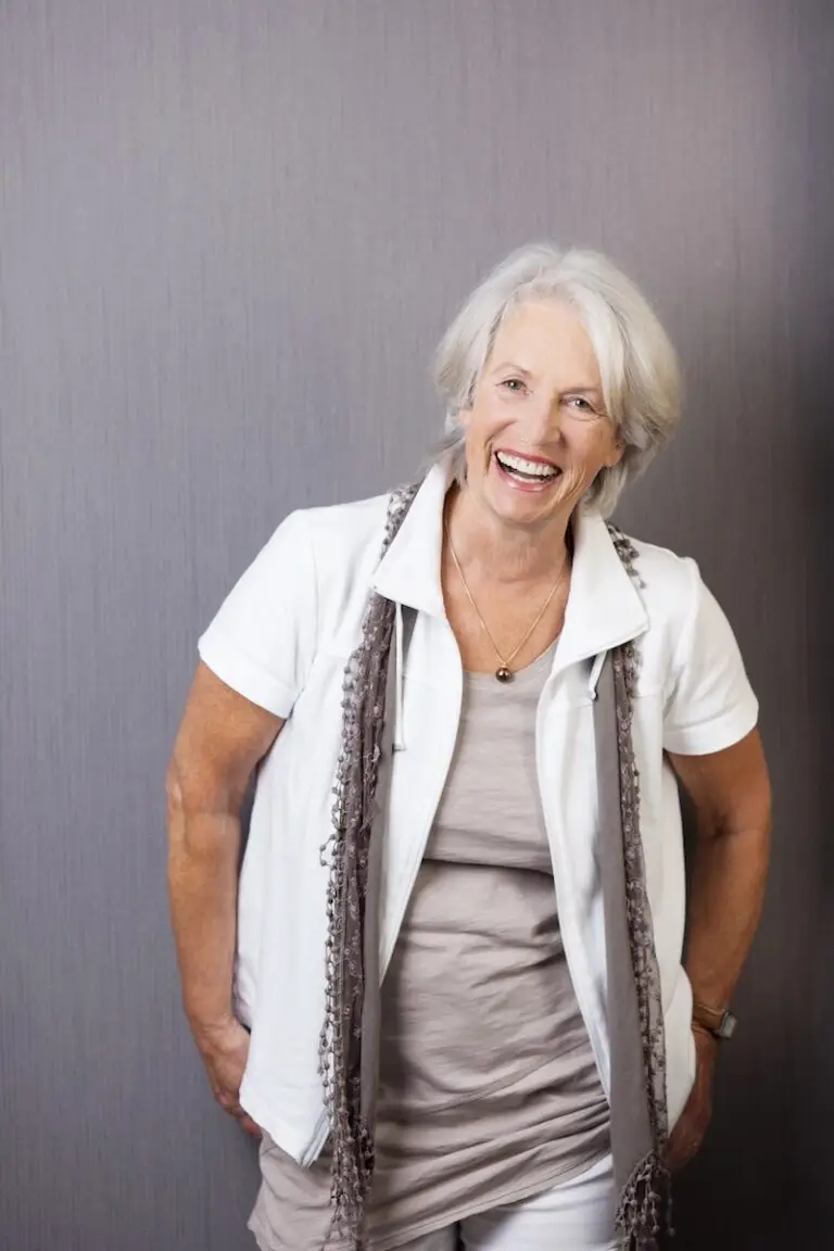 A vibrant senior woman with a youthful smile, representing the empowerment gained through coaching for healthy boundaries.