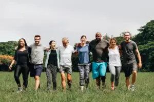 Several people sharing a group hug in a park, illustrating the concept of connection and boundaries in a healthy boundaries quiz.