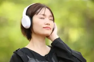 A woman outside, listening to a visualization as part of trauma counselling techniques.