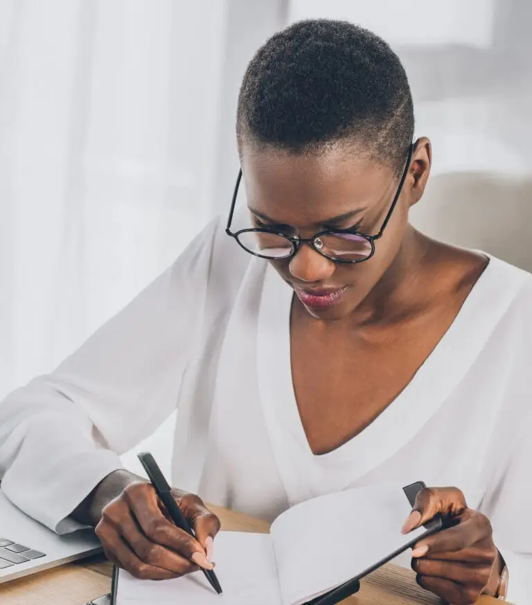 Woman journaling as part of resilience coaching sessions to boost mental strength and personal growth.