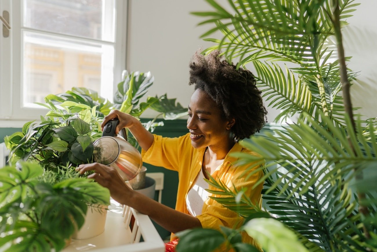 A women taking care of plants as a grounding practice to overcome adversity.