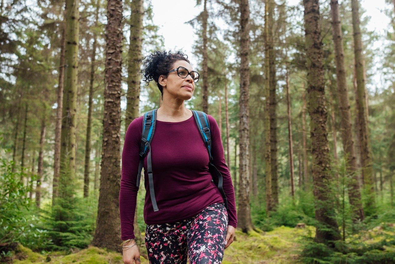 Woman hiking outside in nature to heal from adversity.