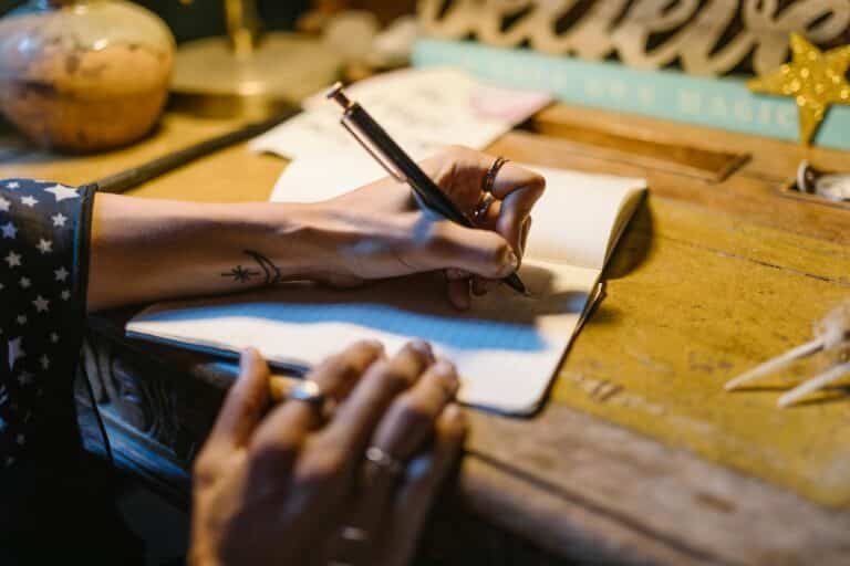 Personal journalling about anxiety and trauma while sitting at a wooden desk.