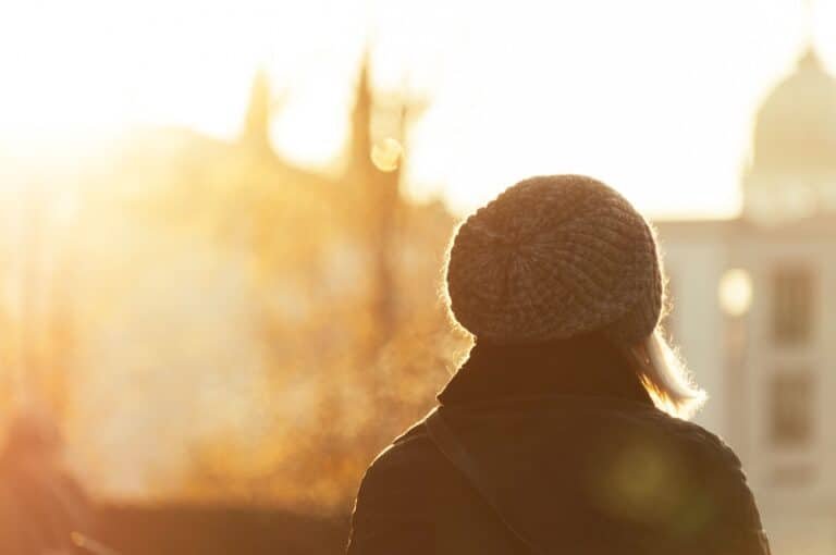Individual outside with a hat with sunshine, symbolizing the healing of signs of childhood trauma in adults