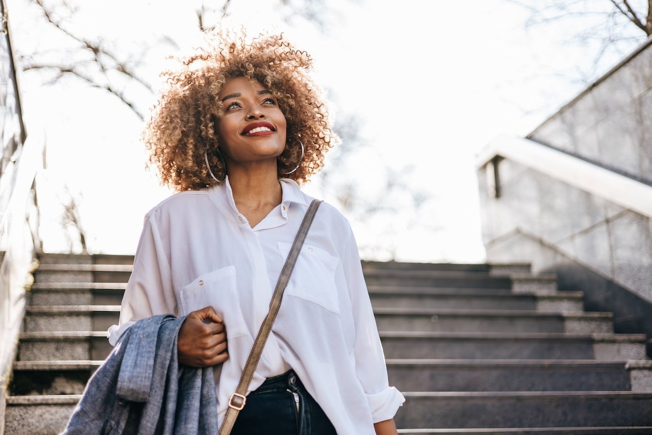 Confident black woman walking down stairs, symbolizing healing with relational trauma counselling.