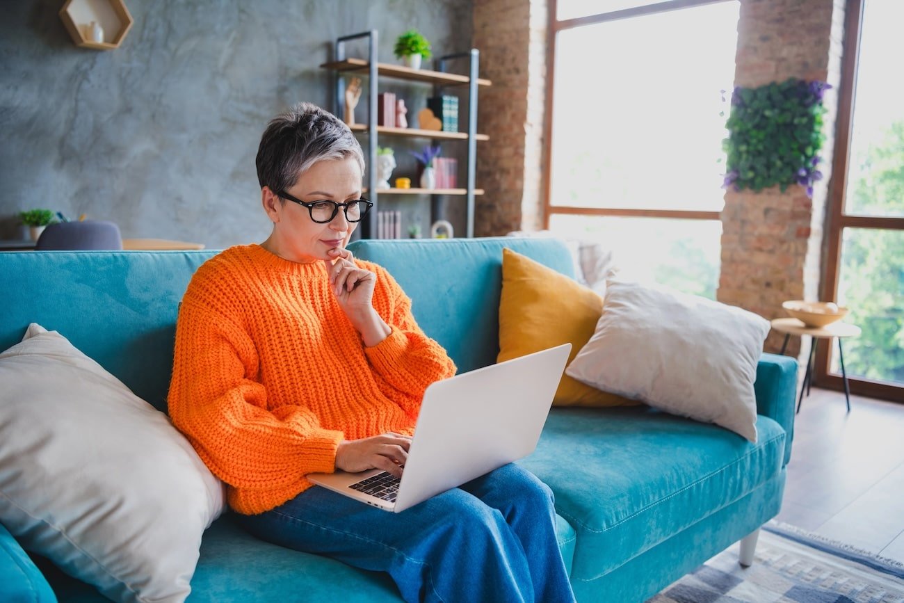 A woman on her sofa in an online session for complex trauma counselling.